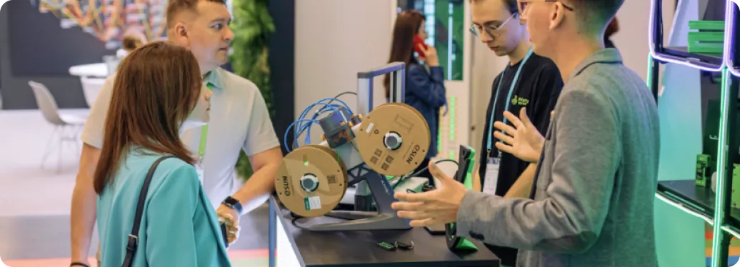 Команда Принти показывает 3D-принтер посетителям выставки